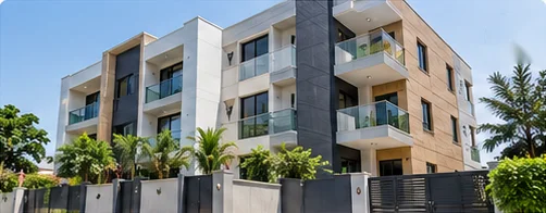 Modern apartment building with balconies behind a gated wall and palm trees